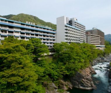 Multi-story riverside hotel buildings along a river at Kinugawa Onsen Hotel, Tochigi, Kantō, Japan