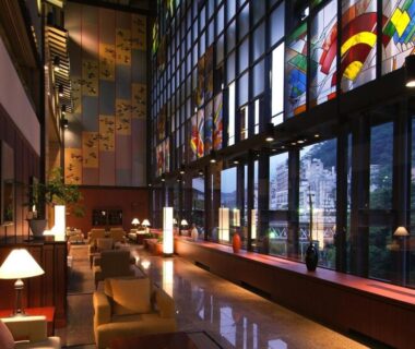 Spacious lobby with floor-to-ceiling stained glass windows, seating area, lamps and polished floors at Kinugawa Plaza Hotel Tochigi