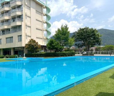 Outdoor swimming pool beside Kinugawa Royal Hotel with mountains and lawn in Tochigi