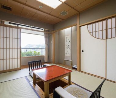 Traditional tatami room with shoji screens, low table and chairs, window overlooking greenery at Kinzan, Hyōgo, Kansai