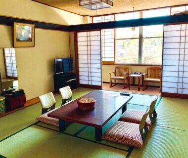 Tatami room with low table, zabuton cushions and shoji screens at Kirishimaya Ryokan in Gunma Kanto