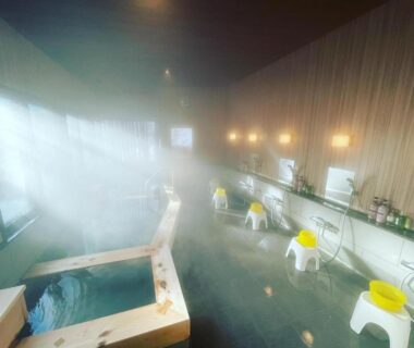 Indoor onsen bath with wooden tub, washing stools and steam at Kirishimaya Ryokan, Gunma, Kantō