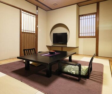 Traditional tatami room with low table, floor cushions, shoji-style windows and circular wall alcove at Kisara, Mie