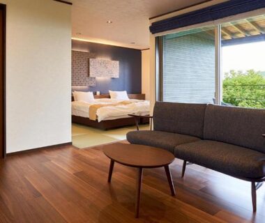 Sofa and low table, bed visible, sliding door opening to garden at Kisara Bettei TOKI Mie