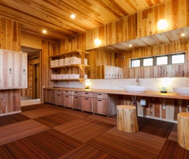 Wood-lined changing area with sinks and wooden stools at Kisara Oneness, Mie, Kansai