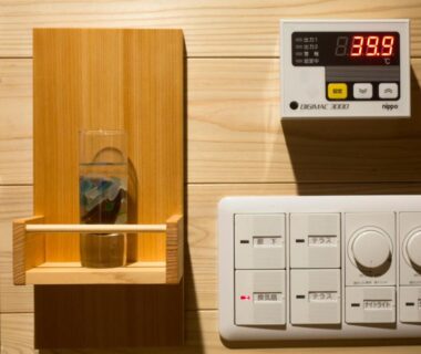 Digital temperature control, light switches and wooden shelf inside ryokan room at Kisara Oneness in Mie, Japan