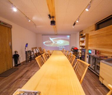 Long wooden table with chairs and projector screen at Kisara Oneness in Mie Kansai