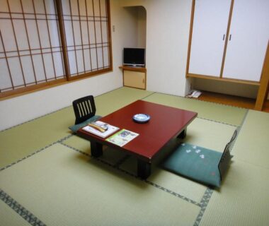 Traditional tatami room with low table, floor cushions, shoji screens and small TV at Kisoya in Gifu prefecture