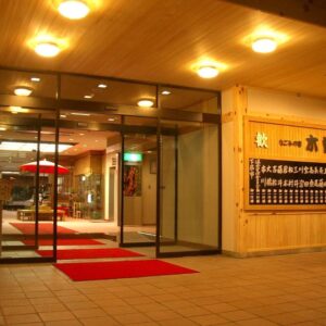 Glass doors and red carpeted entrance with wooden paneling at Kisoya Ryokan in Gifu, Chūbu, Japan