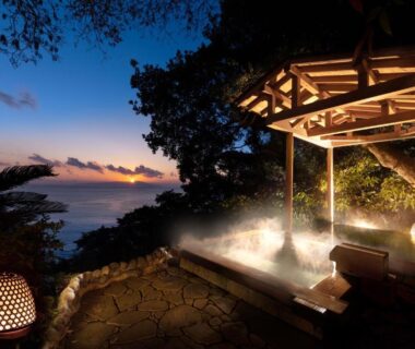 Steaming outdoor onsen on terrace overlooking ocean at dusk with lanterns, Kissho Caren, Shizuoka