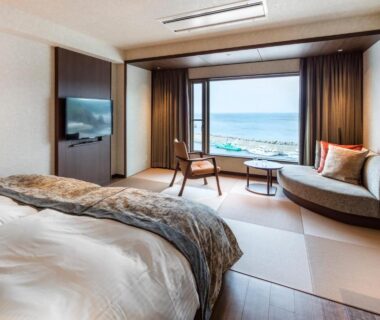 Interior with beds and seating overlooking the coastline at Kitakobushi Shiretoko Hotel, Hokkaidō