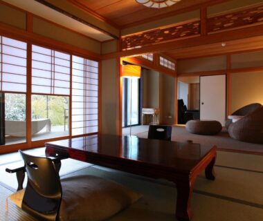 Japanese tatami room with low table, zabuton cushions and shoji screens opening to balcony seating at Kitanokaze Saryo, Kanagawa
