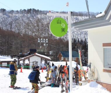 Skiers and equipment by snowy lodge entrance at Kitashiga Holiday Inn, Nagano, Chūbu Japan