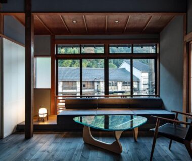 Interior lounge with shoji screens, low glass table, wooden flooring and window view at Kobayashiya in Kinosaki Onsen, Hyōgo
