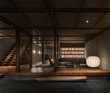 Dim wooden lobby with paper lanterns, low benches and staircase at Kobayashiya Kinosaki Onsen, Hyōgo, Kansai