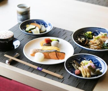 Grilled salmon and side dishes on placemat with chopsticks at Kobe Minato Onsen Ren, Hyōgo