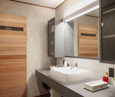 Sink and mirror in Kocho ryokan washroom with wooden door and open shelving, Chūbu, Ishikawa