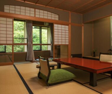 Traditional tatami room with low lacquered table, zaisu chairs and shoji screens overlooking garden at Kocho, Ishikawa