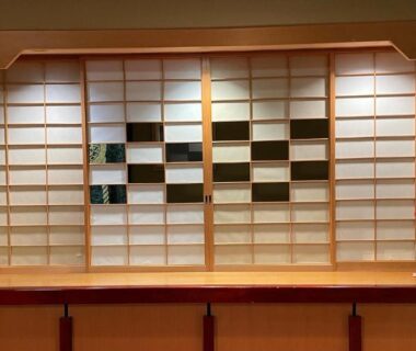 Shoji screen behind wooden reception counter with red flower arrangement at Kocho, Chūbu, Ishikawa, Japan