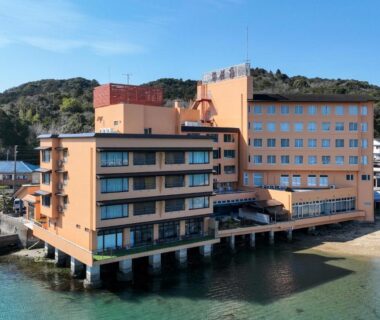 Seaside multi-story ryokan on stilts with balconies overlooking calm water at Kochoran, Mie, Kansai