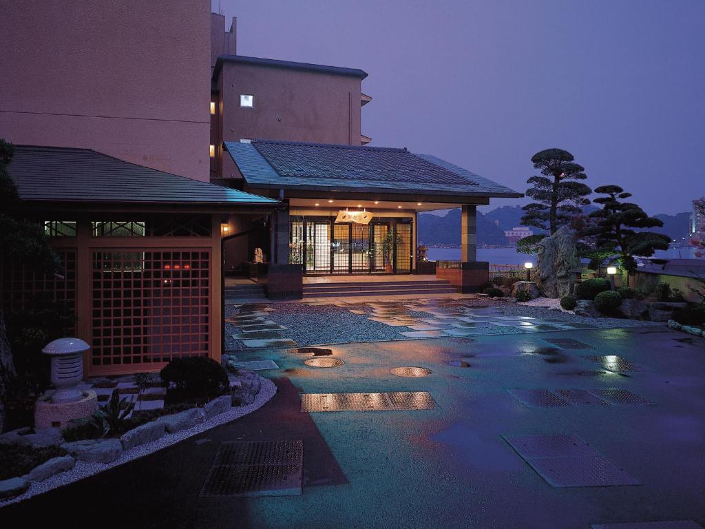 Twilight wet courtyard at Kochoran Mie Lit entrance with wet stone courtyard and stone lantern beside manicured trees at Kochoran in Mie