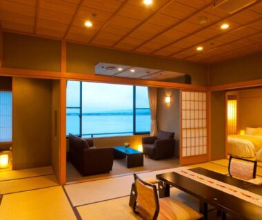 Tatami mats, shoji screens and low table with seating, western bed and waterfront view at Kohan-no-Yado Morimoto Ishikawa