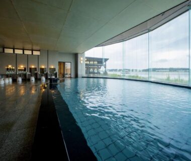 Indoor onsen bath with panoramic water view at Kohan-no-Yado Morimoto in Ishikawa