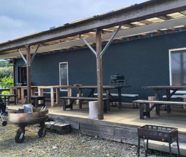 Covered wooden terrace with picnic tables and barbecue grills outside Koinami in Mie, Kansai