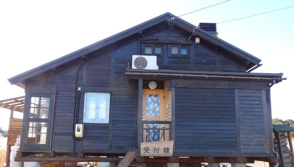 Wooden Ryokan Facade Koinami Mie Dark wooden ryokan exterior with entrance steps and sign at Koinami in Mie, Kansai, Japan