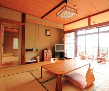 Traditional tatami room with low table, cushions, shoji screens and balcony seating at Kokoronodoka in Shizuoka
