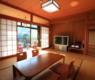 Traditional tatami room with low table, shoji screens and balcony framing mountain views at Kokoronodoka in Shizuoka