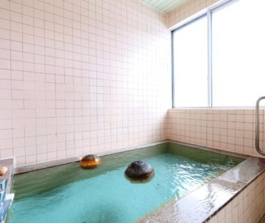 Indoor tiled bathing area with stone accents at Komao ryokan, Nagano, Chūbu, Japan