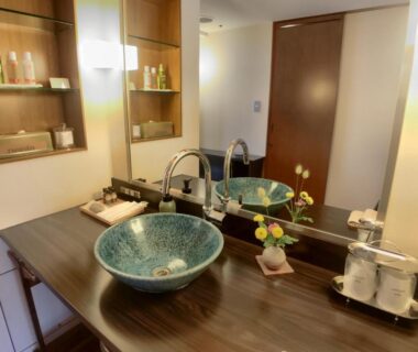 Ceramic basin on wooden vanity with mirror and toiletries at Komatsu-kan Kofu-tei, Miyagi, Tōhoku