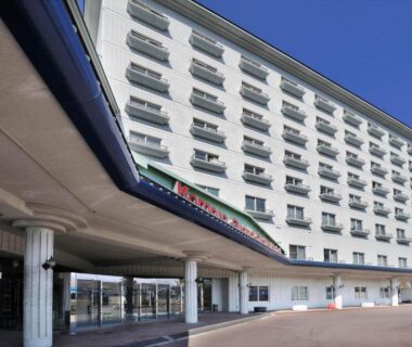 Multi-story hotel facade with balconies and covered entrance at Komoro Grand Castle Hotel in Nagano, Chūbu