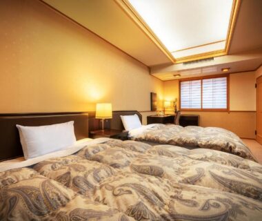 Twin beds with patterned bedspreads, shoji window and wooden interior at Konjakutei, Fukushima Tōhoku