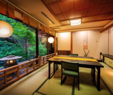 Traditional tatami room with low table and paper lanterns overlooking a lush garden at Konjakutei in Fukushima, Tōhoku