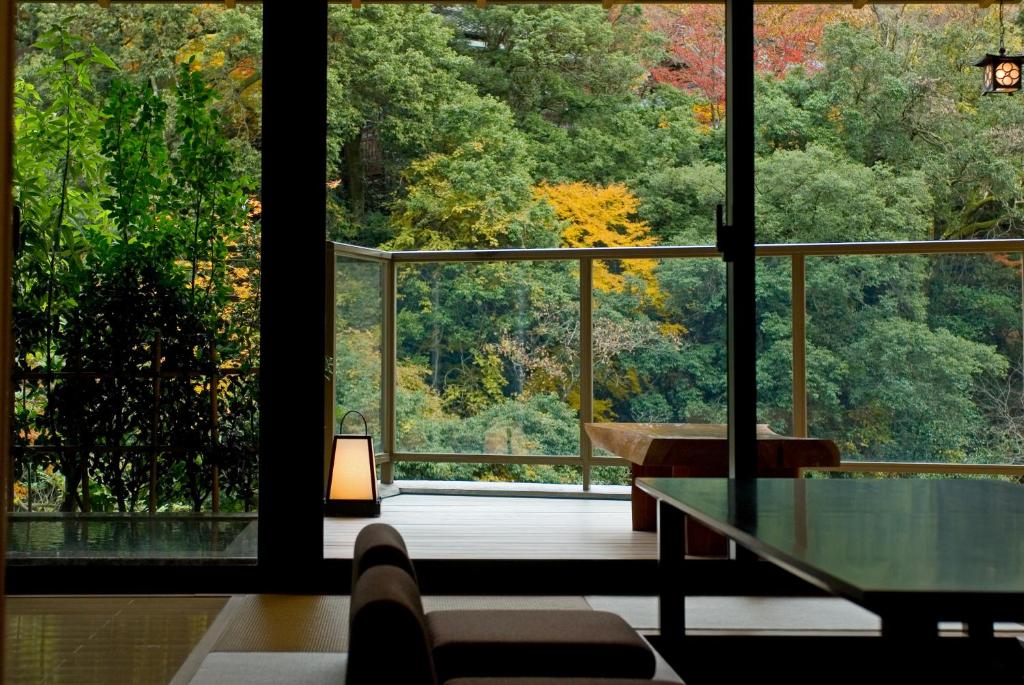 Tatami Room Overlooking Garden Koorogirou Ishikawa Japan Tatami seating with low table and large windows framing tree-covered garden at Koorogirou, Ishikawa