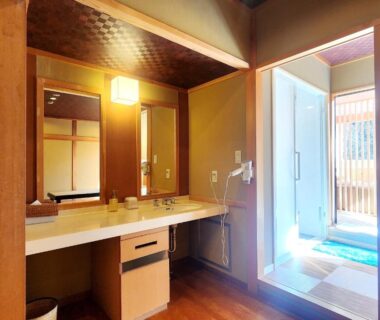 Wooden vanity and mirror beside bright entryway and genkan at Kose Onsen, Nagano, Chūbu, Japan