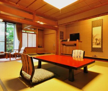 Traditional tatami room with low table, zabuton chairs and tokonoma at Koshi no Yado Takashimaya, Niigata