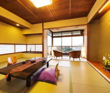 Japanese tatami room with low table, zabuton cushions and balcony seating at Kotobukitei in Mie