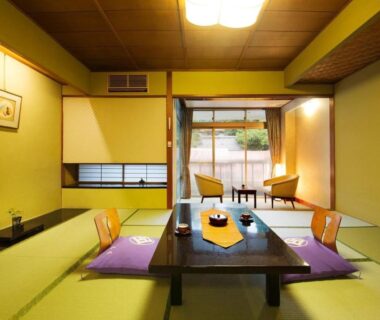 Tatami room with low table, cushions, shoji screens and sliding veranda door at Kotobukitei in Mie, Kansai
