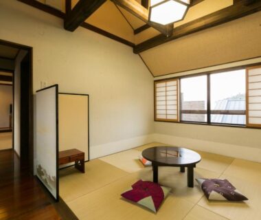 Tatami room with round low table, zabuton cushions and shoji screens at Kotonoyado Musashino in Nara