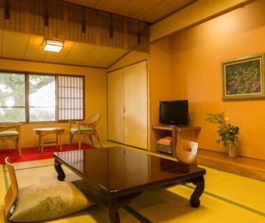Traditional tatami room with low wooden table, zabuton cushions, shoji screens and window seating at Kotonoyado Musashino, Nara