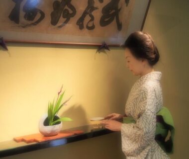Woman in kimono arranging floral display at Kotonoyado Musashino reception in Nara