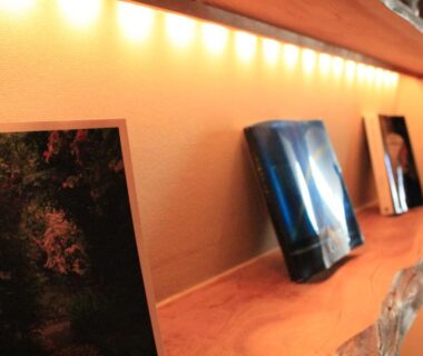 Illuminated wooden shelf displaying framed art panels at Kotsubokaigan Linca in Kanagawa, Kantō