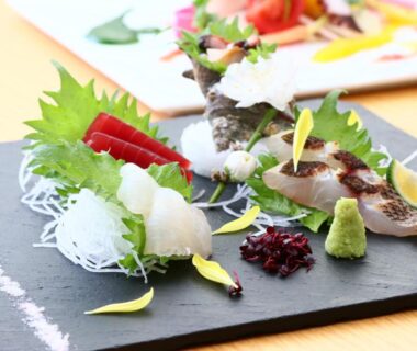 Assorted sashimi on slate with shiso and wasabi at Kotsubokaigan Linca in Kanagawa