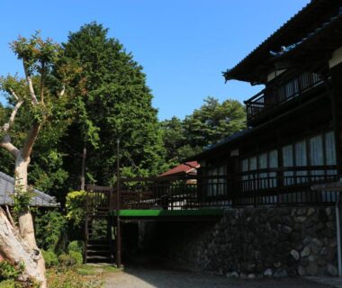 Exterior walkway with wooden facades and sliding windows at Kougetsu Sanso, Tokyo