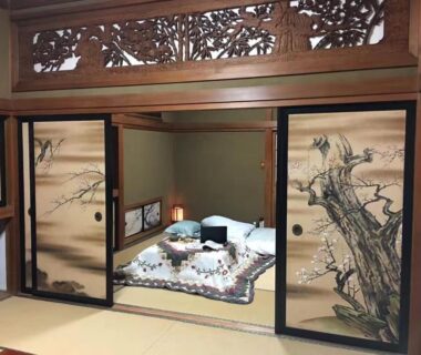 Traditional tatami room with painted fusuma, carved transom, futon bedding and shoji screens at Kougetsu Sanso Tokyo