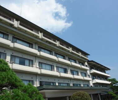 Multi-story ryokan building with balconies and pine trees at Kounkaku in Fukushima Tohoku