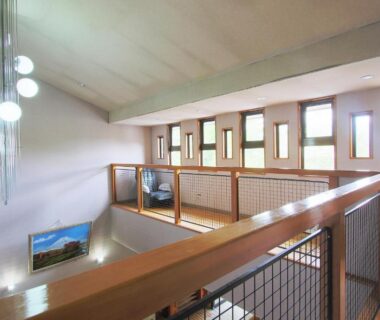 Upper mezzanine corridor with wooden railing and pendant lights, Kounso ryokan, Yamanashi Chūbu region